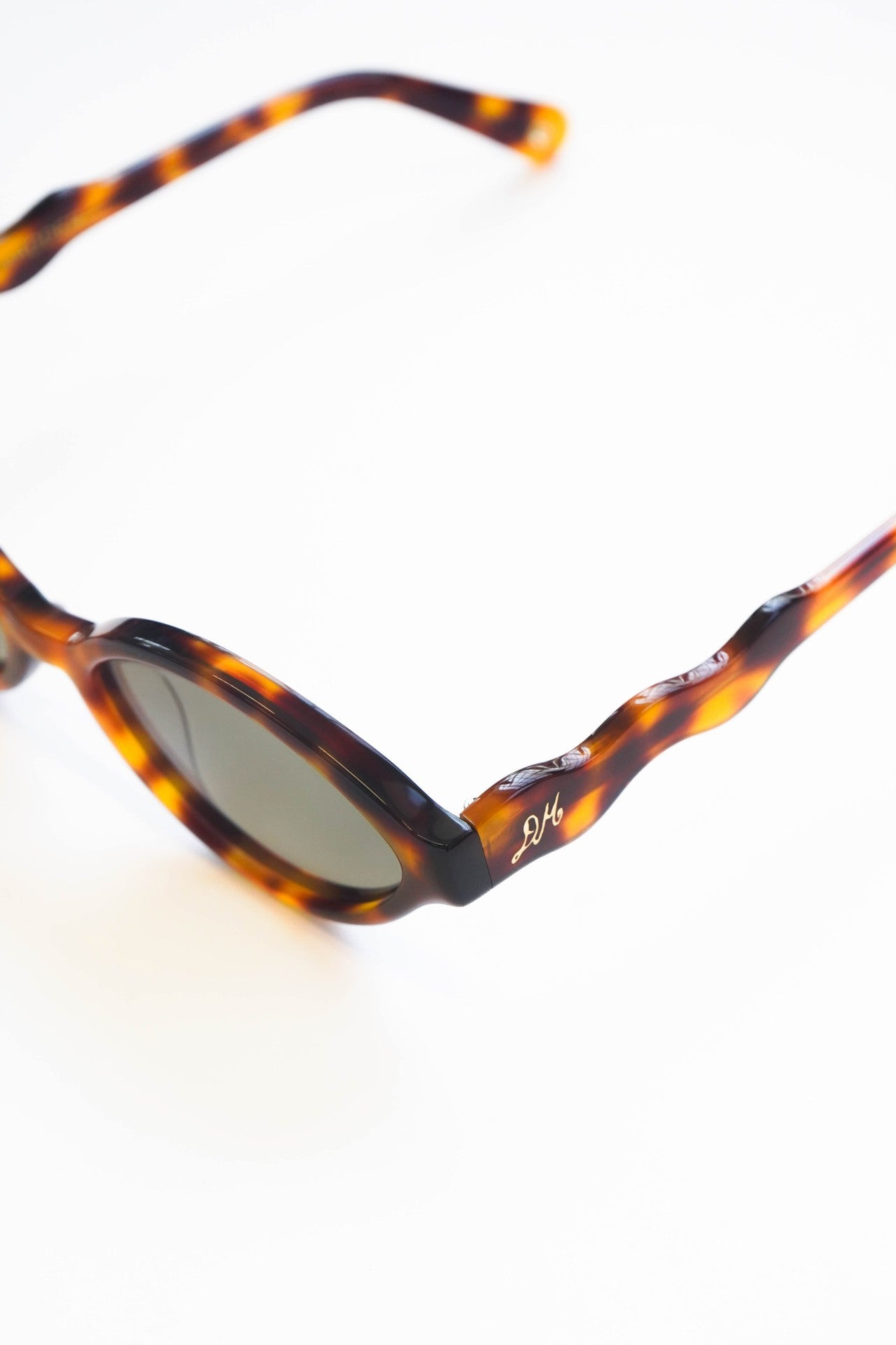 slim oval sunglasses with wavy temple in tort