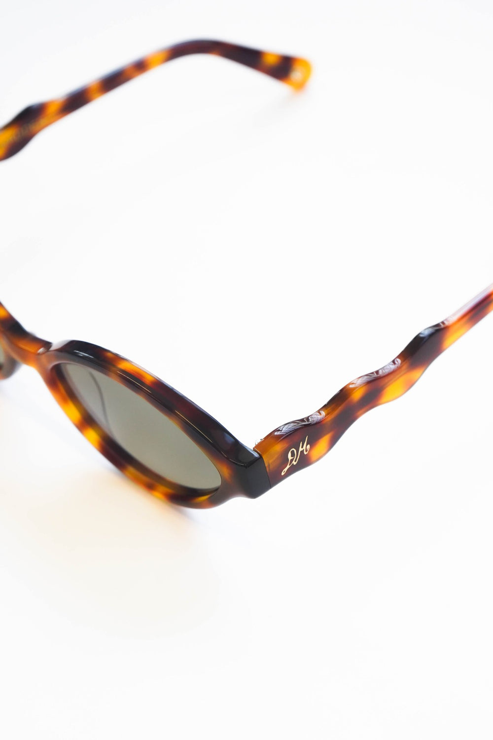 slim oval sunglasses with wavy temple in tort